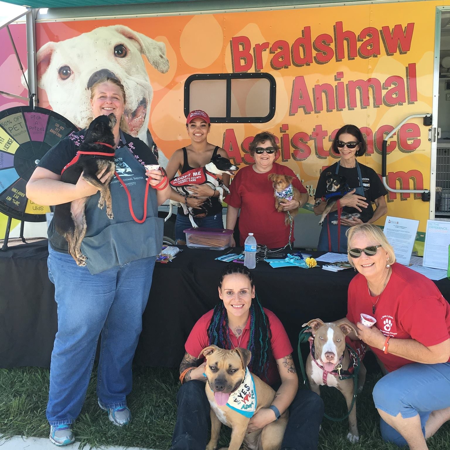 Photo of The Bradshaw Animal Assistance Team outside holding dogs and smiling